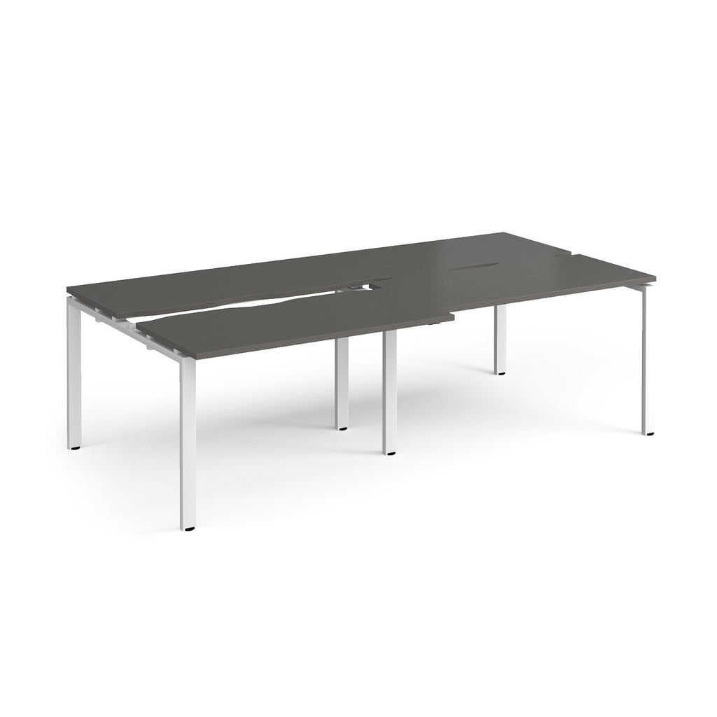 Large modular bench desk with a grey worktop, integrated cable access cut-outs, and white metal legs, shown on a white background.