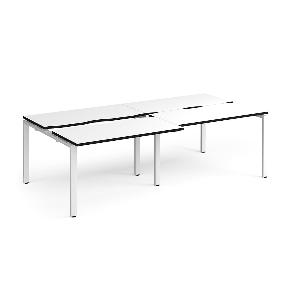 Large modular bench desk with a white worktop, contrasting black edge detail, integrated cable access cut-outs, and white metal legs, shown on a white background.