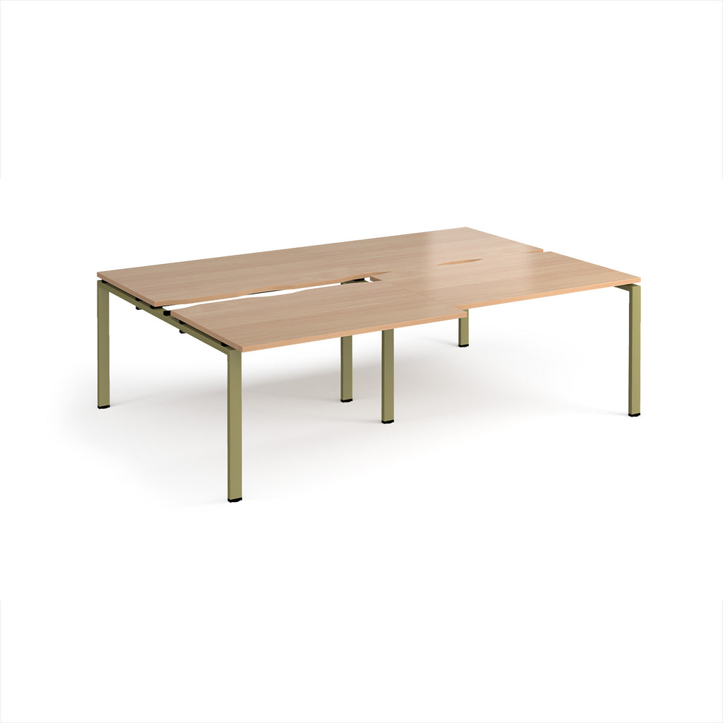 Large modular bench desk with a light wood-effect top, integrated cable access cut-outs, and green metal legs, shown on a white background.