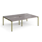 Large modular bench desk with a grey wood-effect top, integrated cable access slots, and green metal legs, shown on a white background.