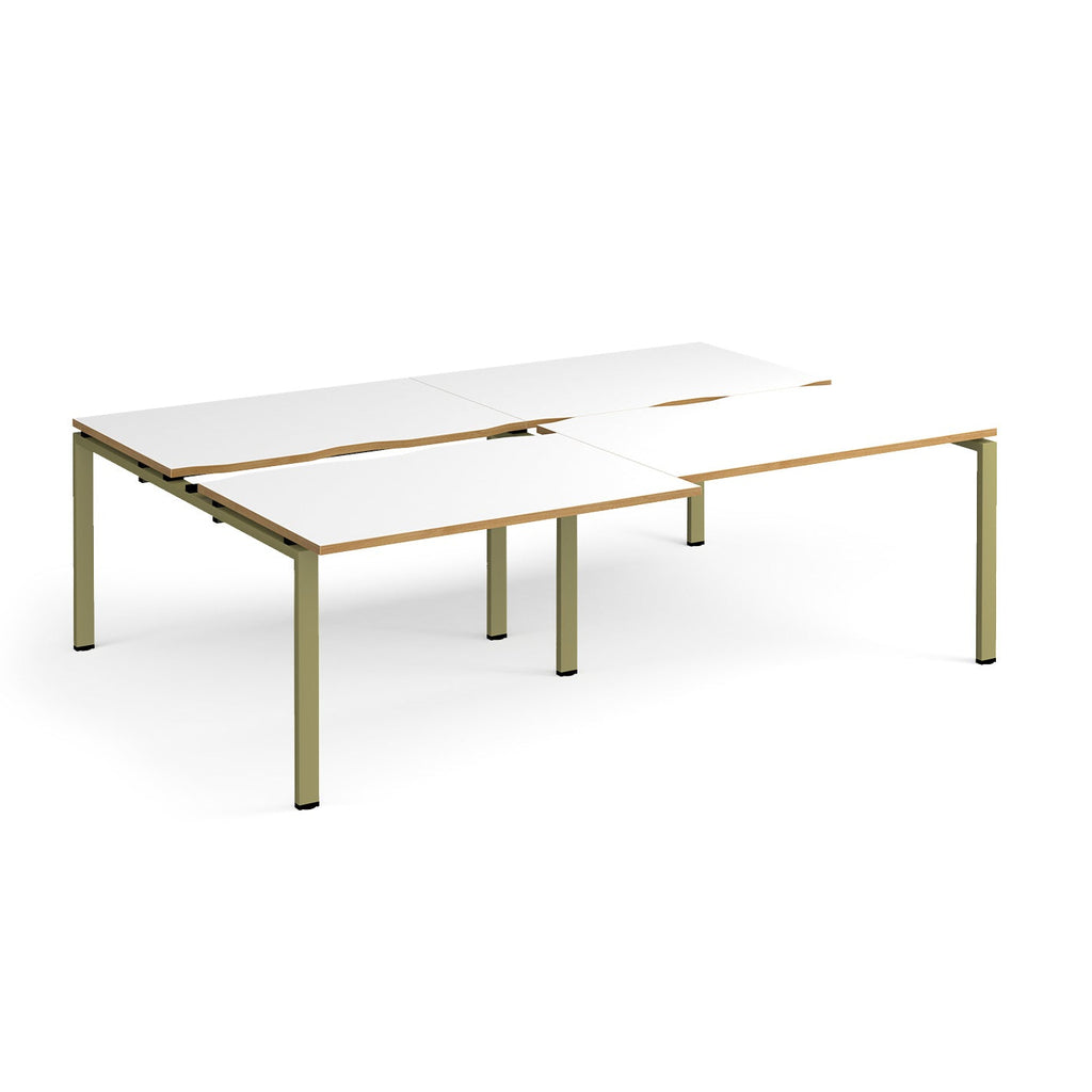 Large modular bench desk with white panels and wood-effect edging, integrated cable access cut-outs, and green metal legs, shown on a white background.