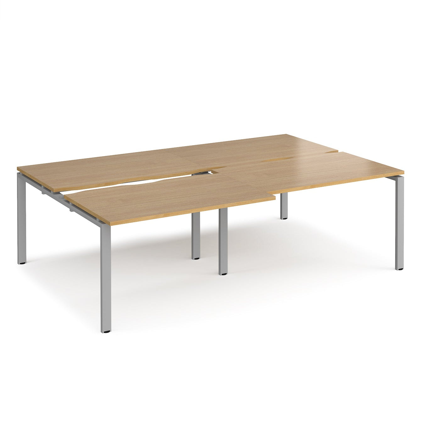 Large modular bench desk with a light oak wood-effect top, integrated cable access cut-outs, and silver metal legs, shown on a white background.