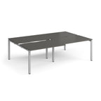 Large modular bench desk with a grey worktop, integrated cable access cut-outs, and silver metal legs, shown on a white background.