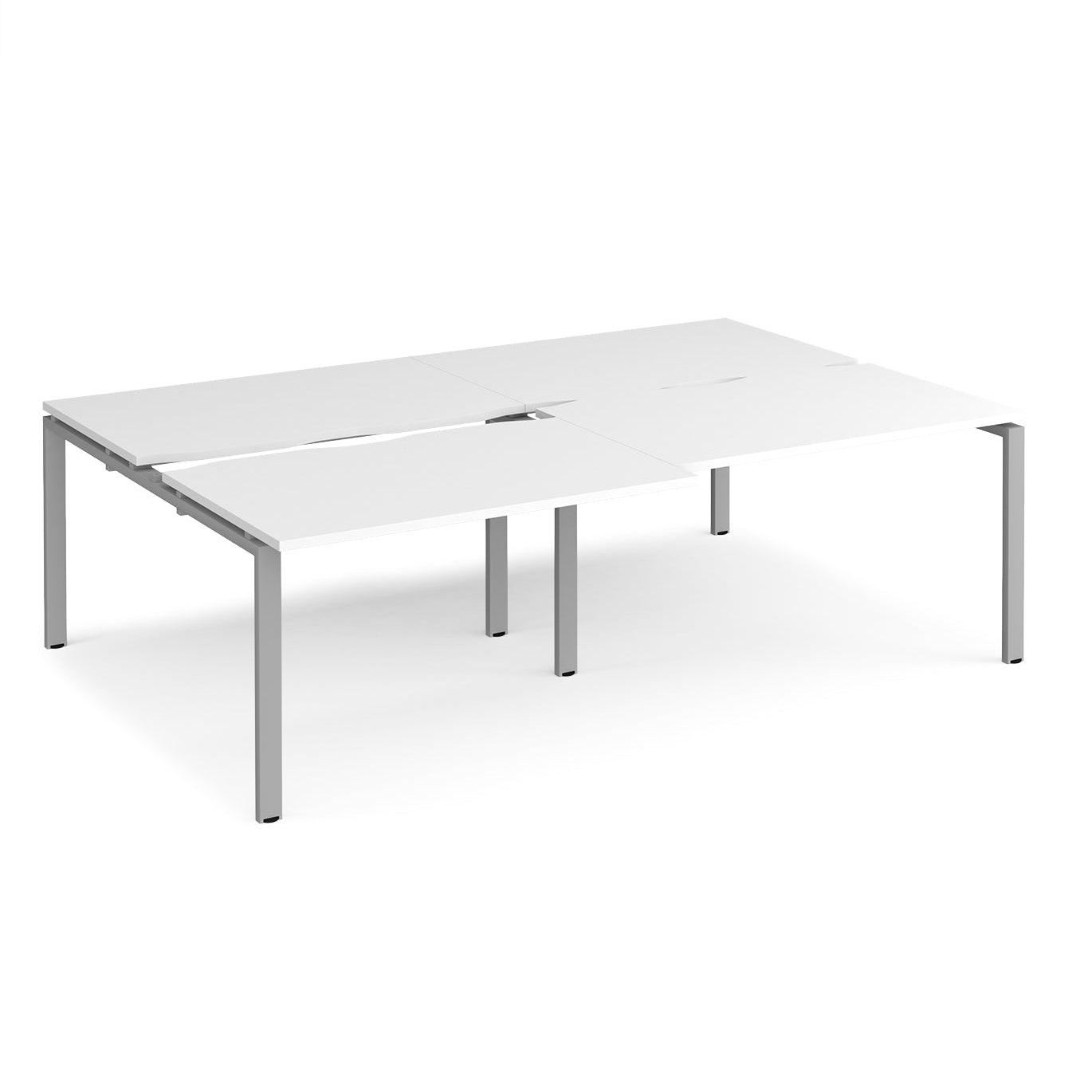 Large modular bench desk with a white worktop, integrated cable access cut-outs, and silver metal legs, shown on a white background.