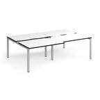 Large modular bench desk with a white worktop, contrasting black edge detail, integrated cable access cut-outs, and silver metal legs, shown on a white background.