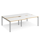 Large modular bench desk with white panels and wood-effect edging, integrated cable access cut-outs, and silver metal legs, shown on a white background.