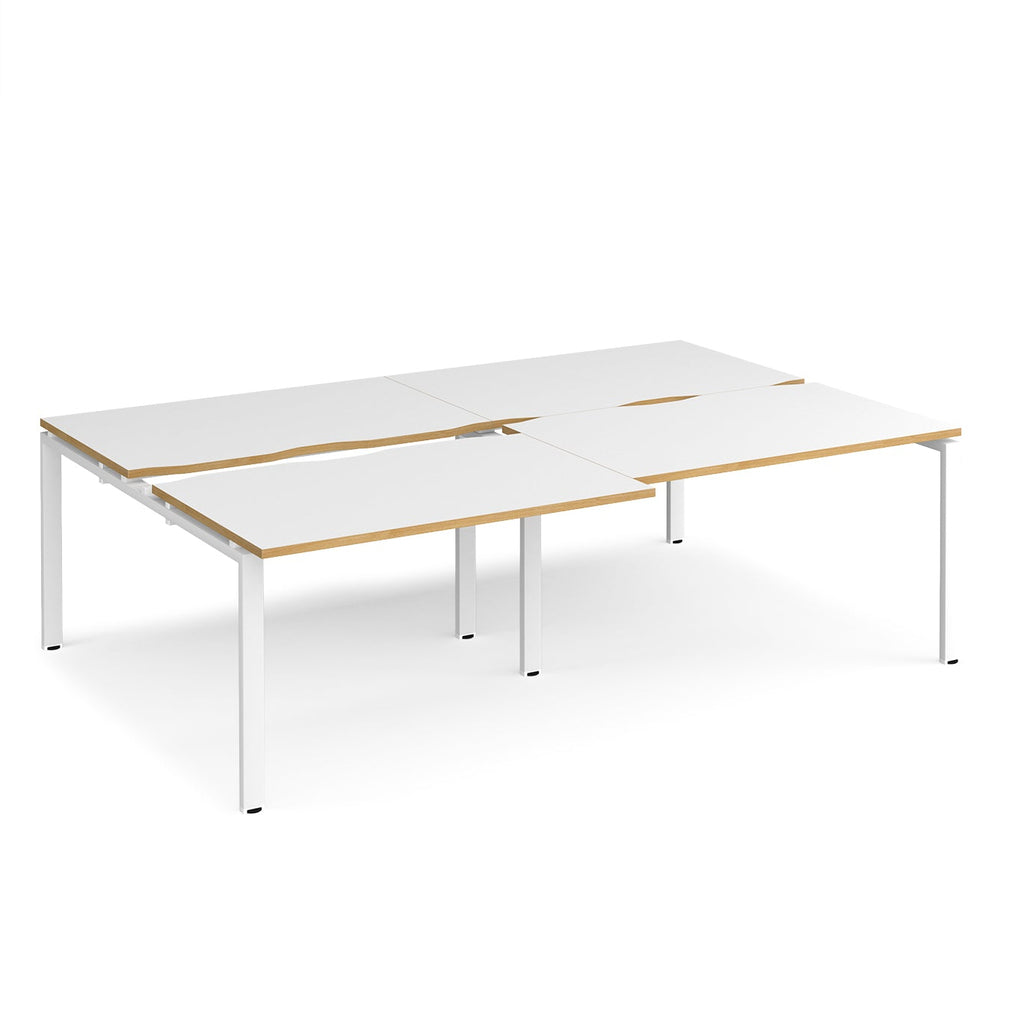 Large modular bench desk with white panels and wood-effect edging, integrated cable access cut-outs, and white metal legs, shown on a white background.