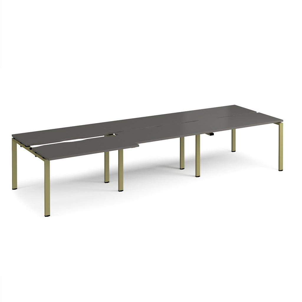 Large modular bench desk with a dark grey worktop, integrated cable access cut-outs, and green metal legs, shown on a white background.