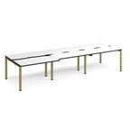Large modular bench desk with a white worktop, contrasting black edge detail, integrated cable access cut-outs, and green metal legs, shown on a white background.