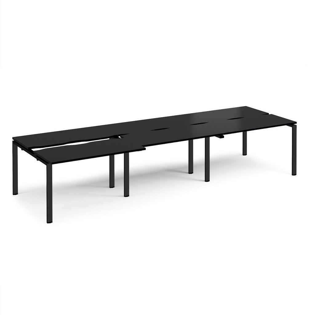 Large modular bench desk with a black worktop, integrated cable access cut-outs, and matching black metal legs, shown on a white background.