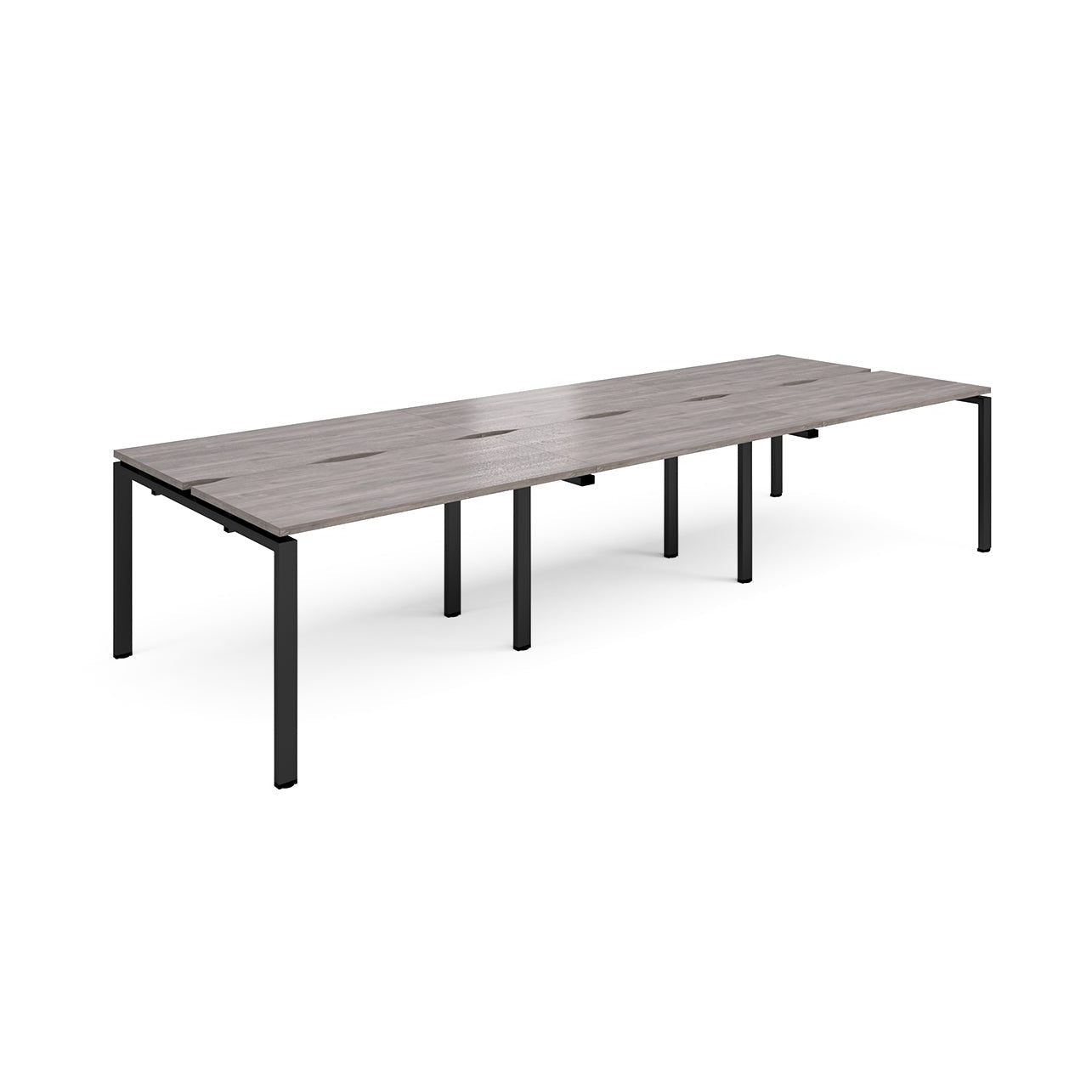 Large modular bench desk with a grey wood-effect top, integrated cable access slots, and black metal legs, shown on a white background.