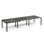 Large modular bench desk with a dark grey worktop, integrated cable access cut-outs, and black metal legs, shown on a white background.