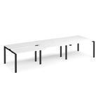 Large modular bench desk with a white worktop, integrated cable access cut-outs, and black metal legs, shown on a white background.