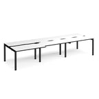 Large modular bench desk with a white worktop, contrasting black edge detail, integrated cable access cut-outs, and black metal legs, shown on a white background.