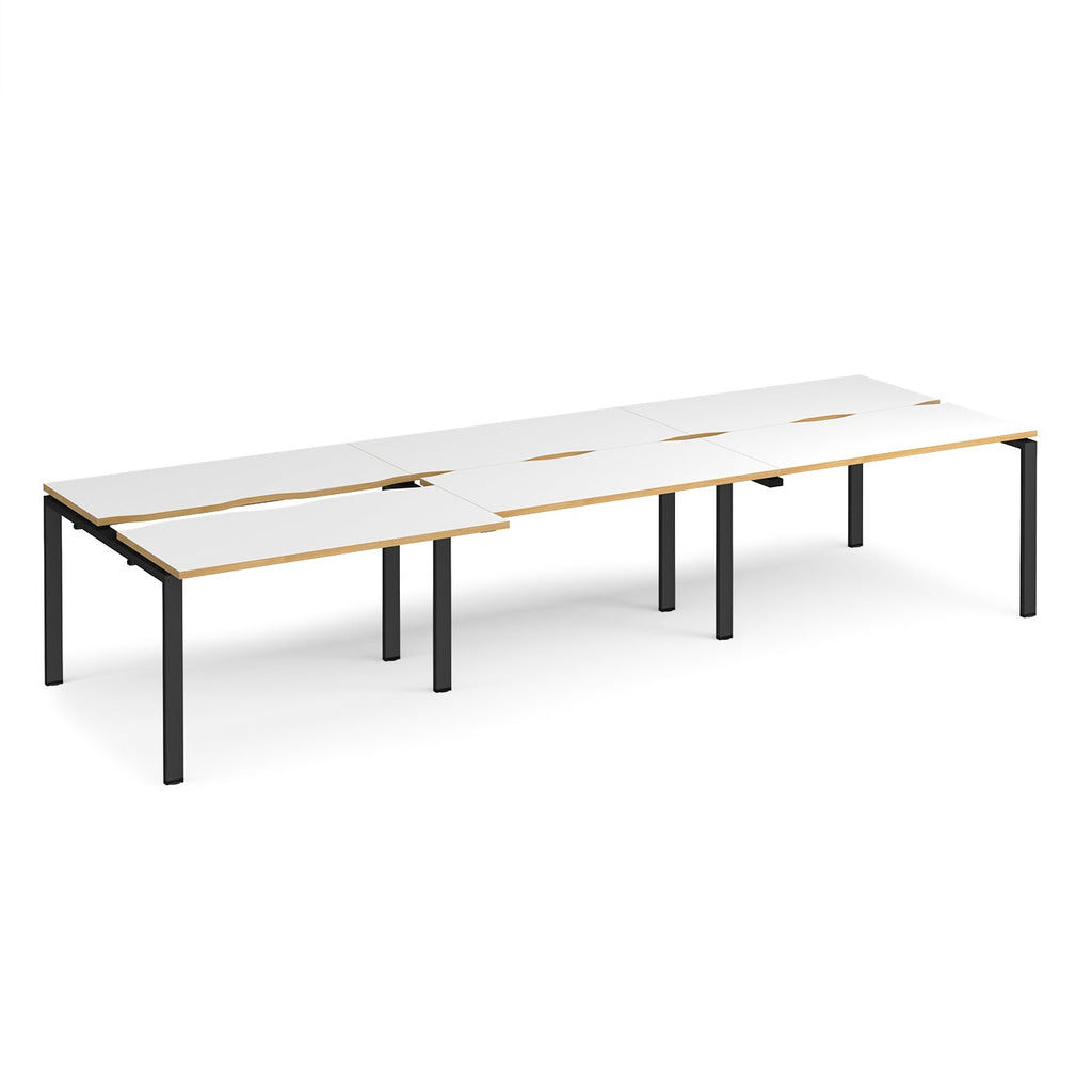Large modular bench desk with white panels and wood-effect edging, integrated cable access cut-outs, and black metal legs, shown on a white background.