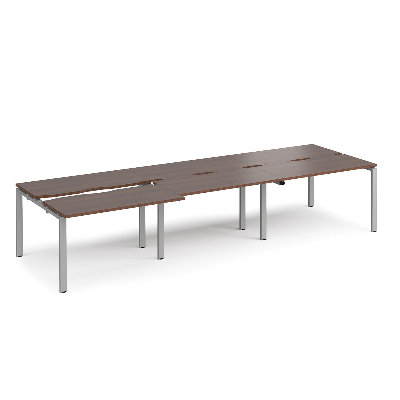 Large modular bench desk with dark wood-effect panels, integrated cable cut-outs, and silver metal legs, shown on a white background.