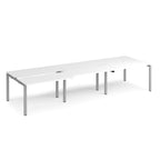 Large modular bench desk with a clean white finish, integrated cable access cut-outs, and silver metal legs, shown on a white background.