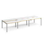 Large modular bench desk with white panels, wood-effect edging, integrated cable cut-outs, and silver metal legs, shown on a white background.