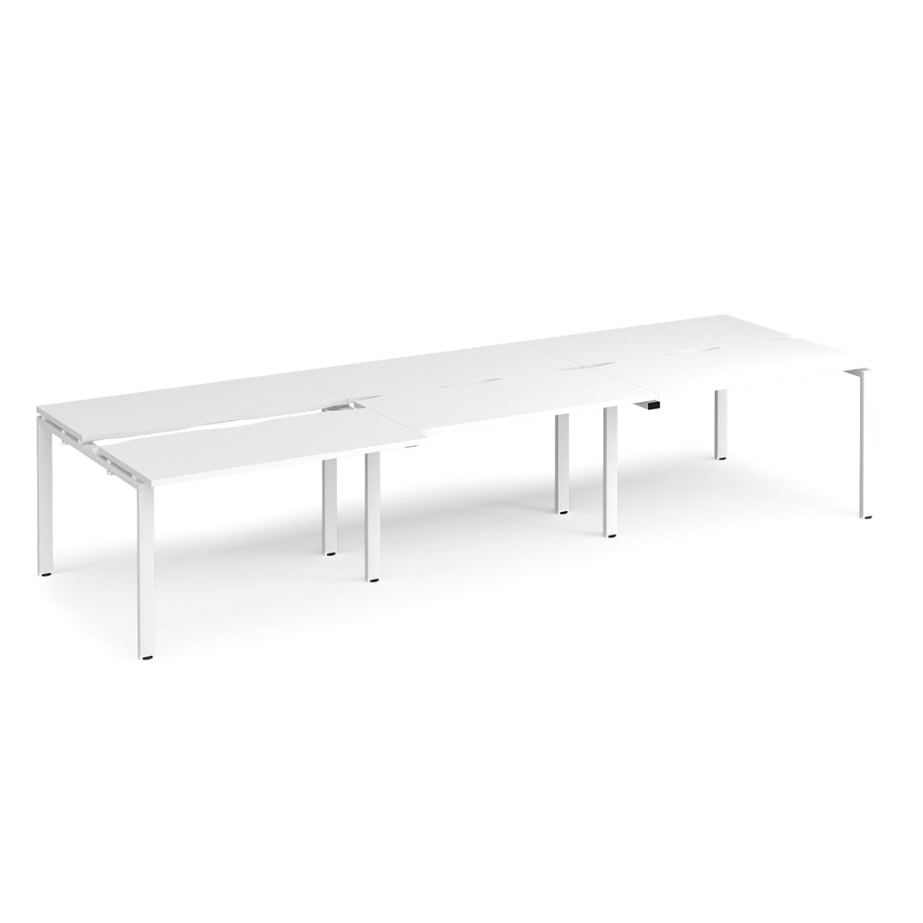 Large modular bench desk with a white worktop, integrated cable access cut-outs, and white metal legs, shown on a white background.