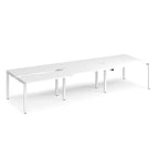 Large modular bench desk with a white worktop, integrated cable access cut-outs, and white metal legs, shown on a white background.