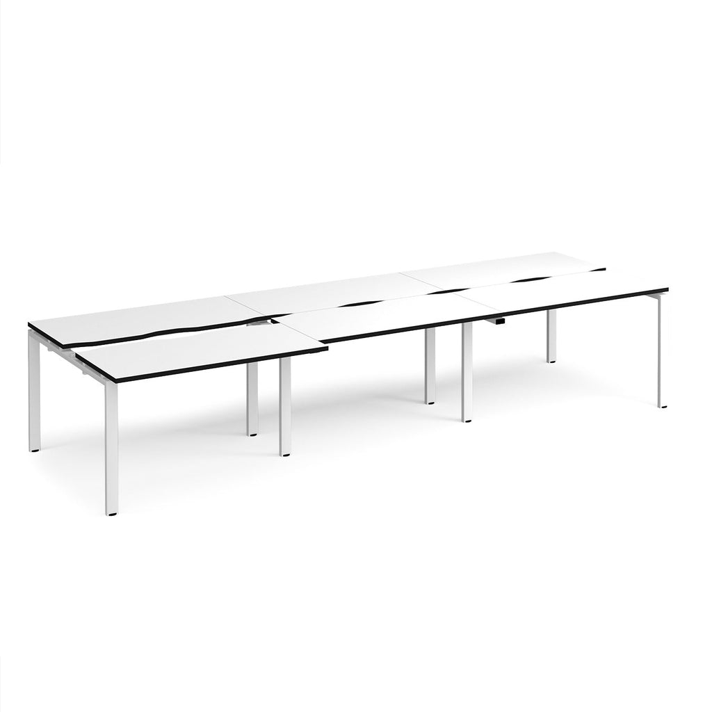 Large modular bench desk with a white worktop, contrasting black edge detail, integrated cable access cut-outs, and white metal legs, shown on a white background.
