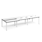 Large modular bench desk with a white worktop, contrasting black edge detail, integrated cable access cut-outs, and white metal legs, shown on a white background.