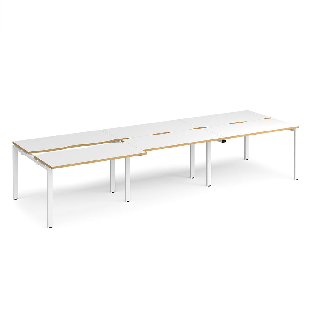 Large modular bench desk with white panels and wood-effect edging, integrated cable access cut-outs, and silver metal legs, shown on a white background.