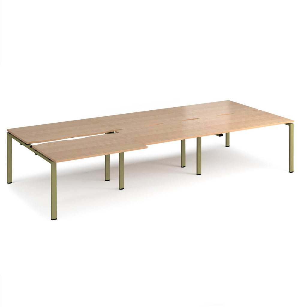 Large modular bench desk with a light wood-effect top, integrated cable access cut-outs, and green metal legs, shown on a white background.