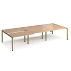 Large modular bench desk with a light wood-effect top, integrated cable access cut-outs, and green metal legs, shown on a white background.