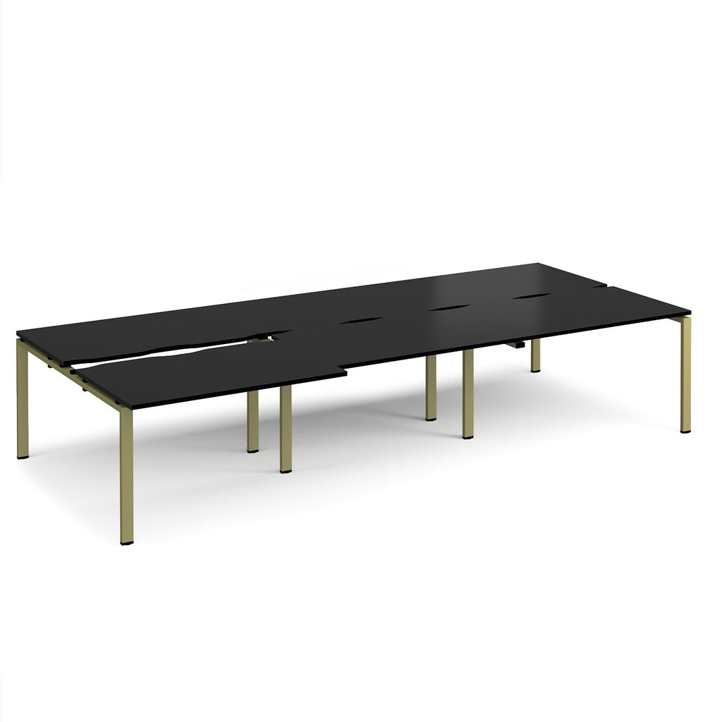 Large modular bench desk with a black worktop, integrated cable access cut-outs, and green metal legs, shown on a white background.