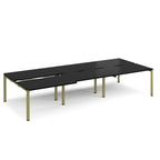 Large modular bench desk with a black worktop, integrated cable access cut-outs, and green metal legs, shown on a white background.