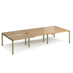 Large modular bench desk with a light oak wood-effect top, integrated cable access cut-outs, and green metal legs, shown on a white background.