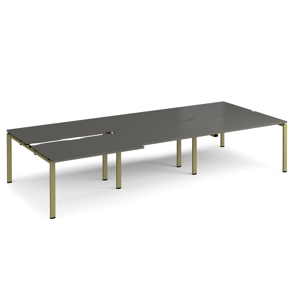Large modular bench desk with a dark grey worktop, integrated cable access cut-outs, and green metal legs, shown on a white background.