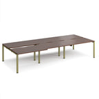 Large modular bench desk with a dark wood-effect top, integrated cable access cut-outs, and green metal legs, shown on a white background.