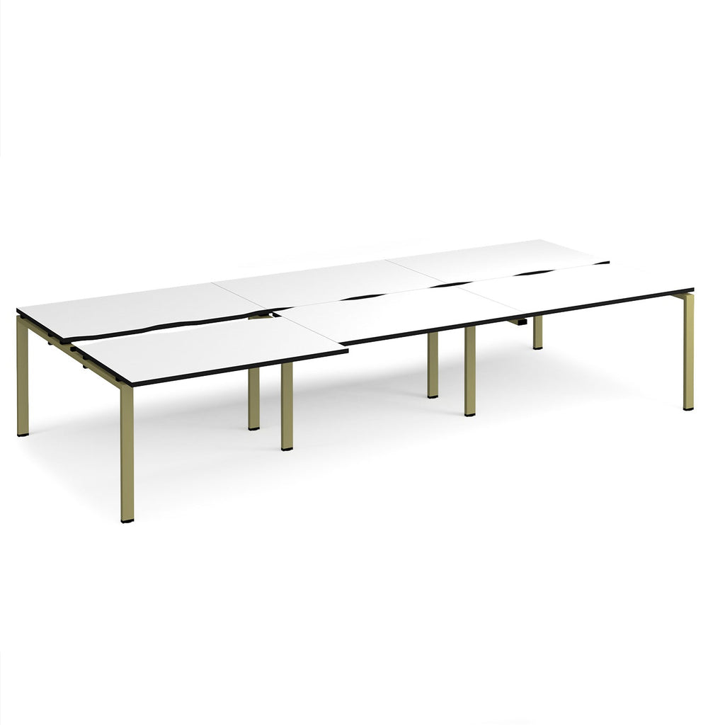 Large modular bench desk with a white worktop, contrasting black edge detail, integrated cable access cut-outs, and green metal legs, shown on a white background.