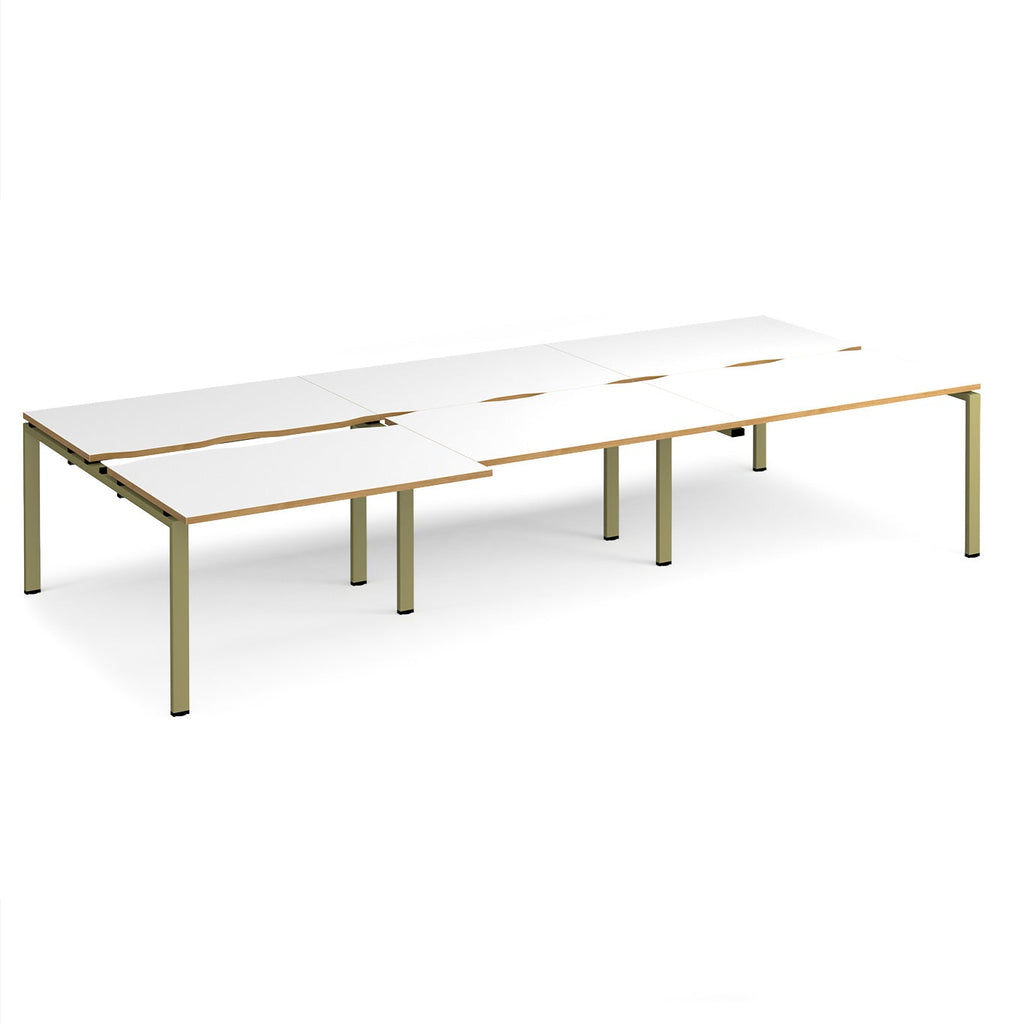Large modular bench desk with white panels and wood-effect edging, integrated cable access cut-outs, and green metal legs, shown on a white background.
