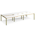 Large modular bench desk with white panels and wood-effect edging, integrated cable access cut-outs, and green metal legs, shown on a white background.