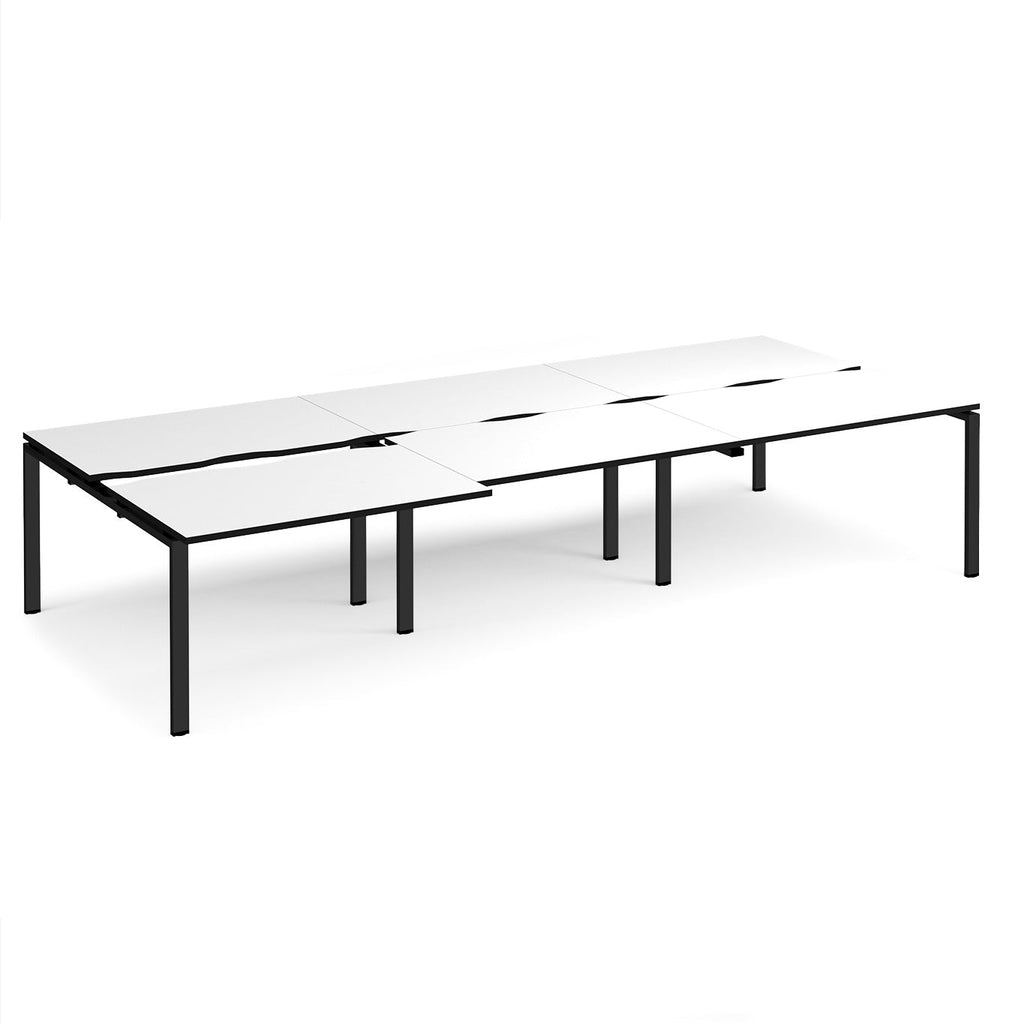 Large modular bench desk with a white worktop, contrasting black edge detail, integrated cable access cut-outs, and black metal legs, shown on a white background.