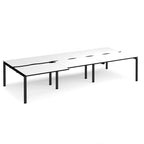 Large modular bench desk with a white worktop, contrasting black edge detail, integrated cable access cut-outs, and black metal legs, shown on a white background.