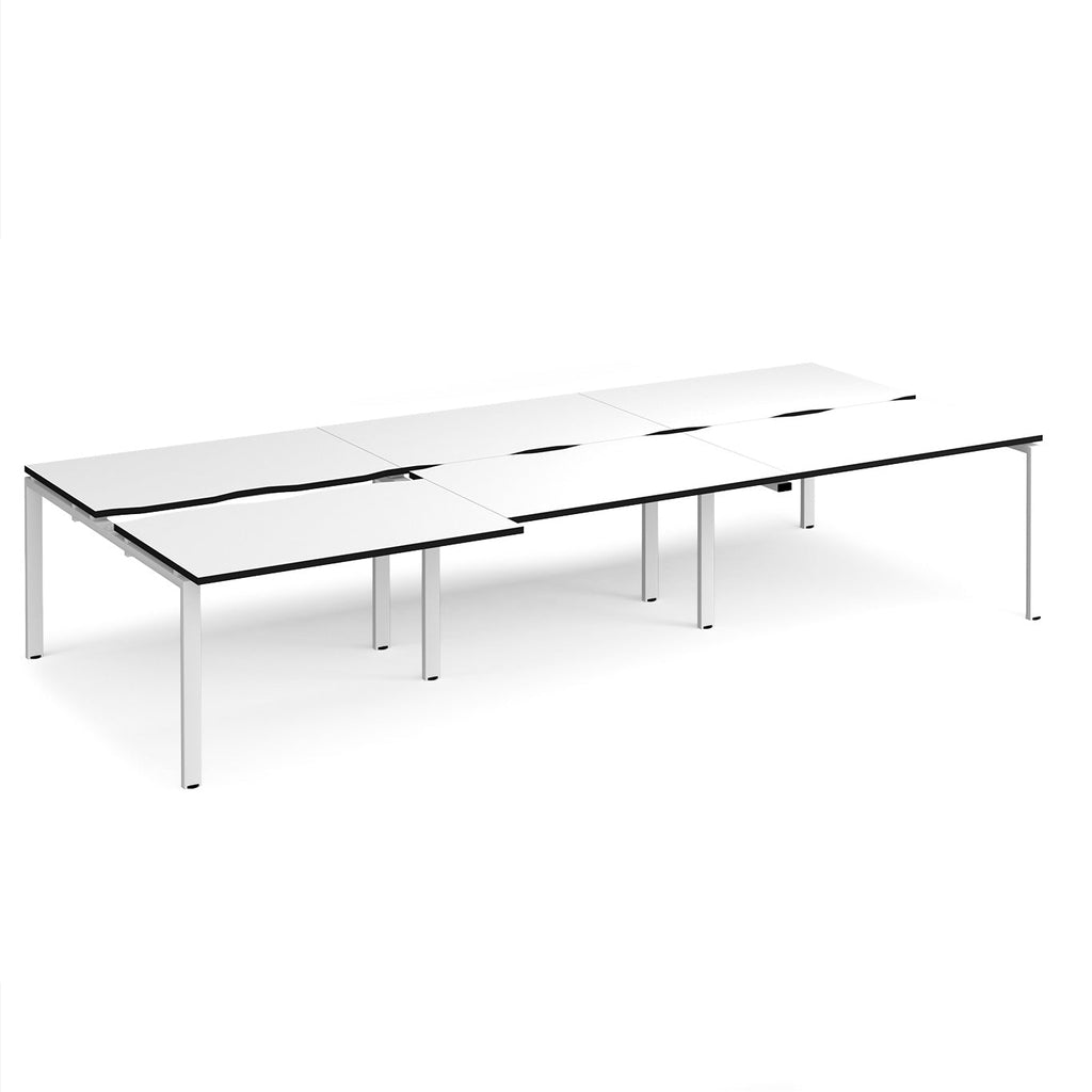 Large modular bench desk with a white worktop, contrasting black edge detail, integrated cable access cut-outs, and white metal legs, shown on a white background.