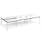 Large modular bench desk with a white worktop, contrasting black edge detail, integrated cable access cut-outs, and white metal legs, shown on a white background.