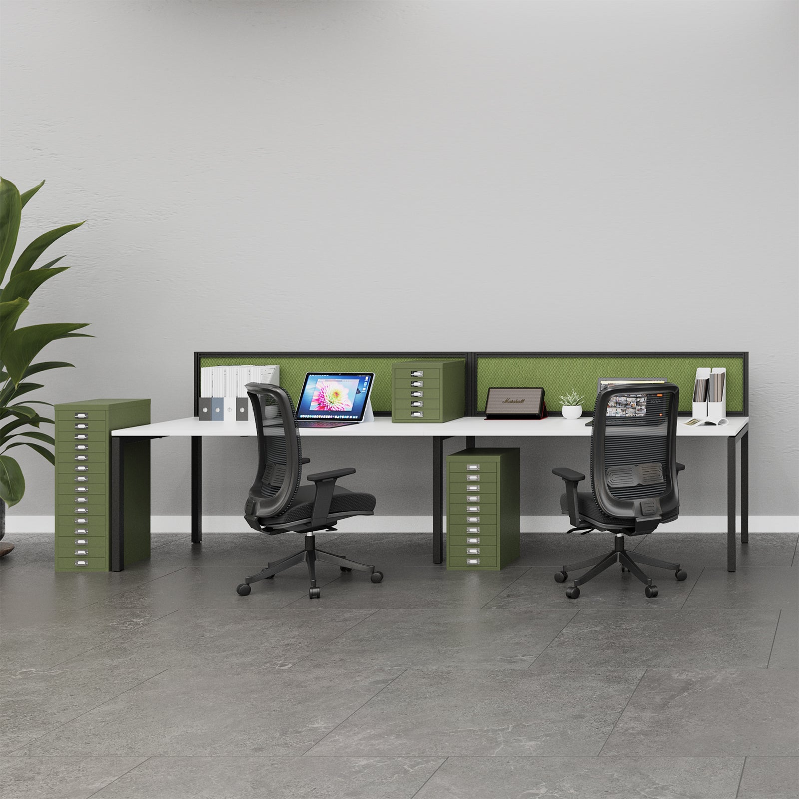 A modern two-person office desk setup with a white desk surface, olive green privacy dividers and storage cabinets, and two black mesh office chairs in a bright, minimalist office space.