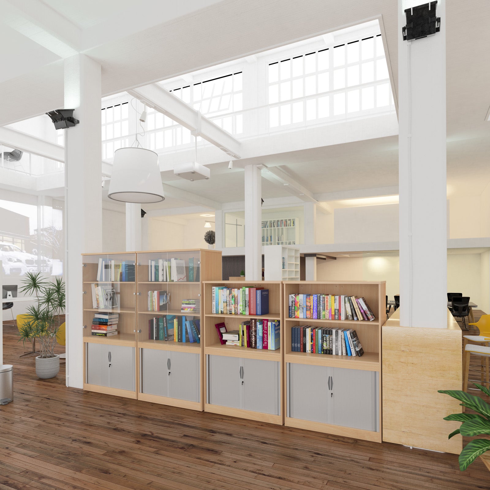 Open-plan office with a row of wood-effect bookcases featuring open shelving and lockable storage, used as a space divider in a bright, modern workplace.