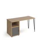 Home office desk with a wood-effect tabletop, integrated storage unit with open shelf and grey door, and slim black hairpin legs, shown on a white background.
