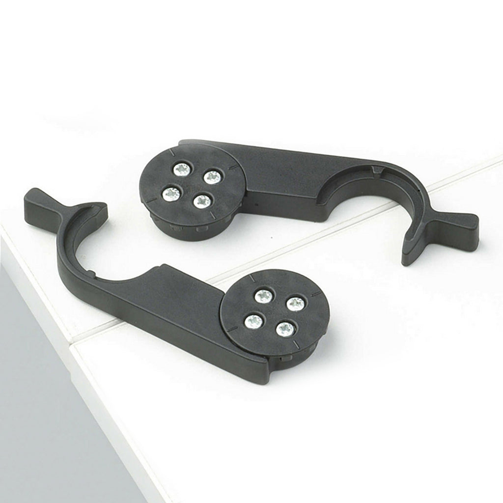 Black metal bracket with circular components on a white surface