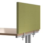 Green fabric desk divider panel clamped to a wooden office desk, providing privacy and acoustic separation in a workspace.