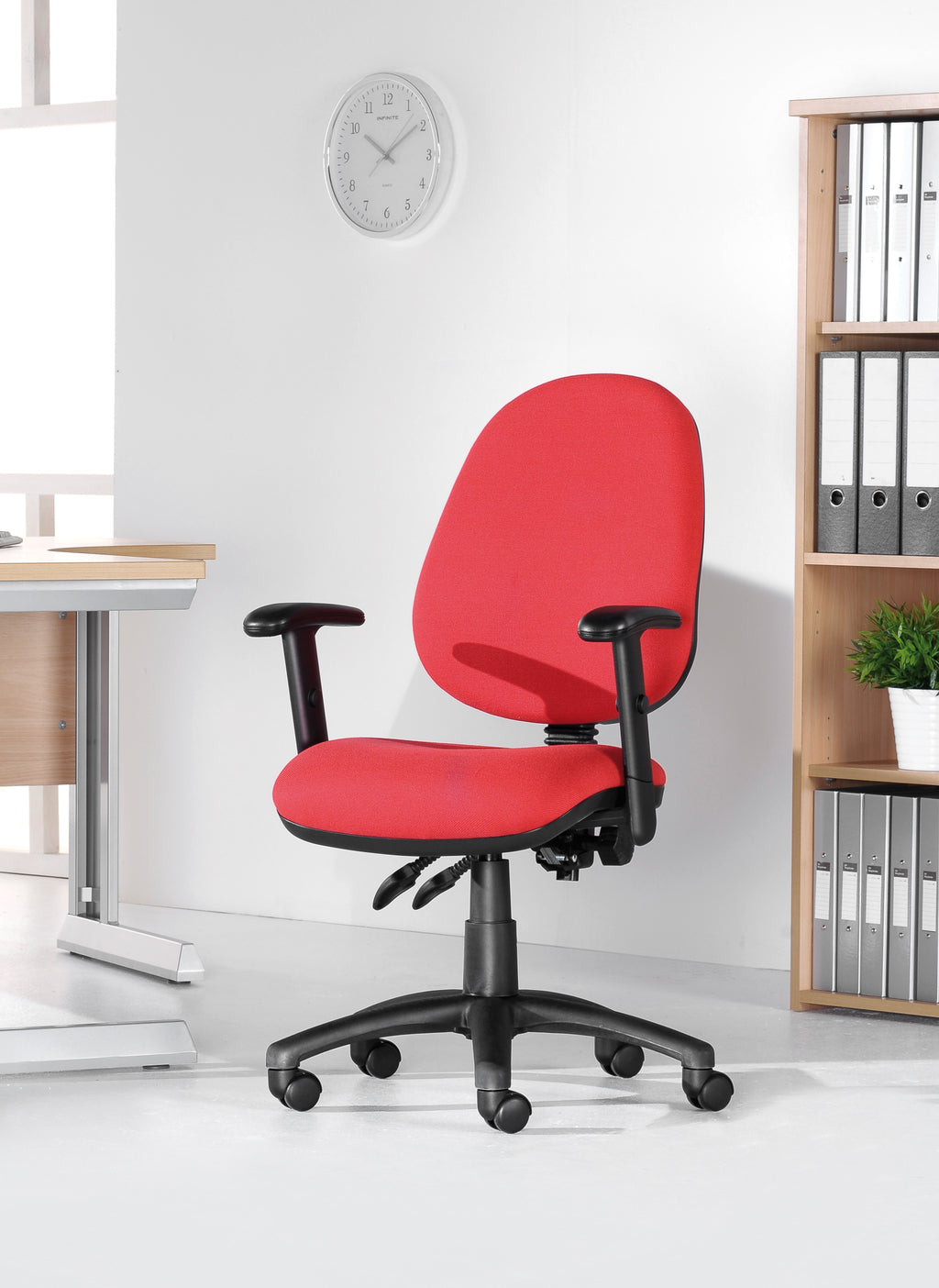 Red office chair in a room with a desk and bookshelf.