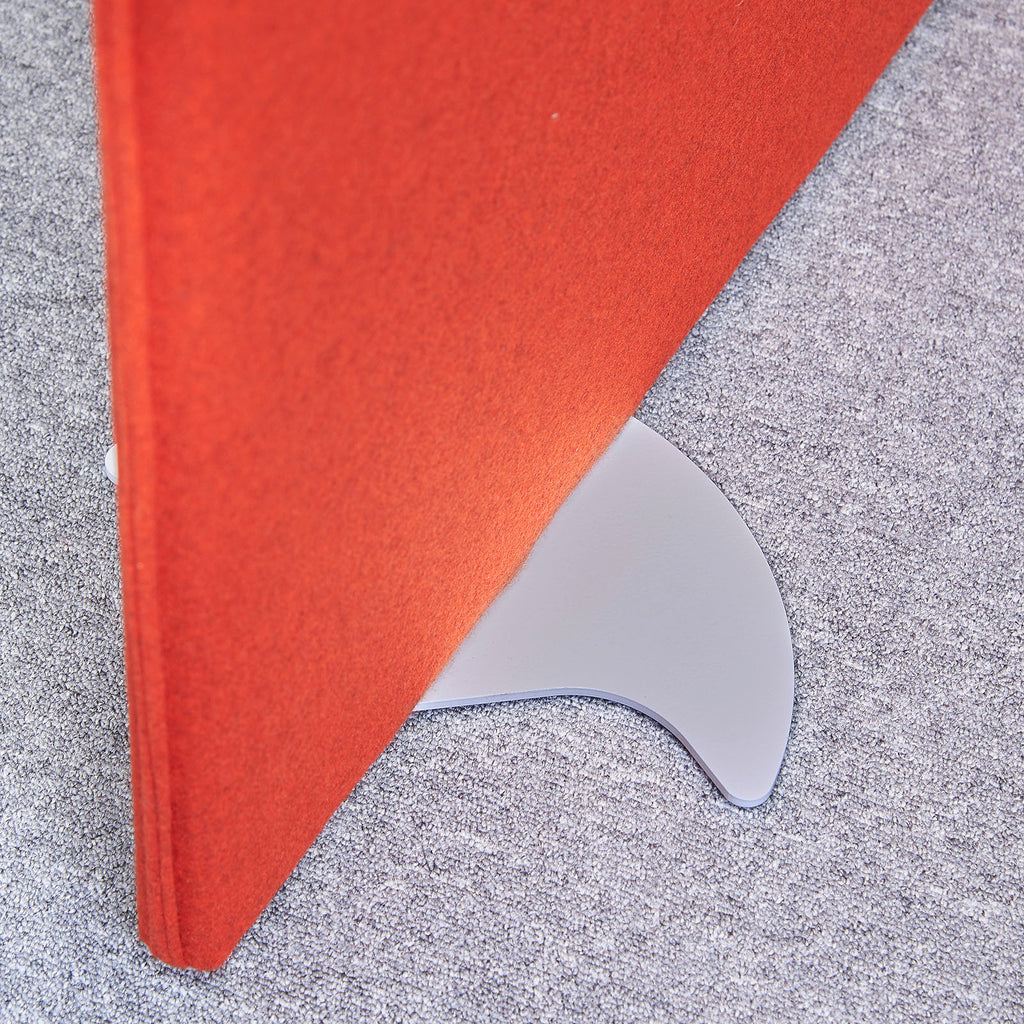 Close-up of a red fabric office screen panel secured in a curved metal free-standing foot, positioned on a carpeted floor.