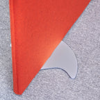 Close-up of a red fabric office screen panel secured in a curved metal free-standing foot, positioned on a carpeted floor.