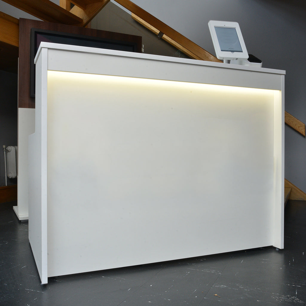 White reception desk with a digital display in an indoor setting